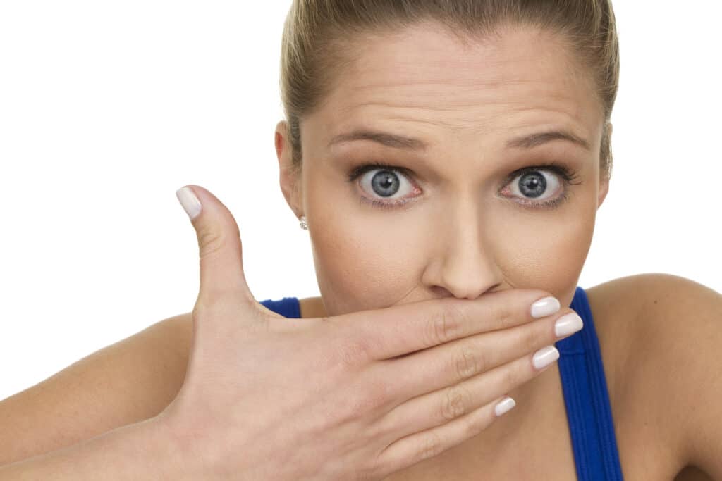 "close up of beautiful surprised woman holding her mouth, isolated on white background"