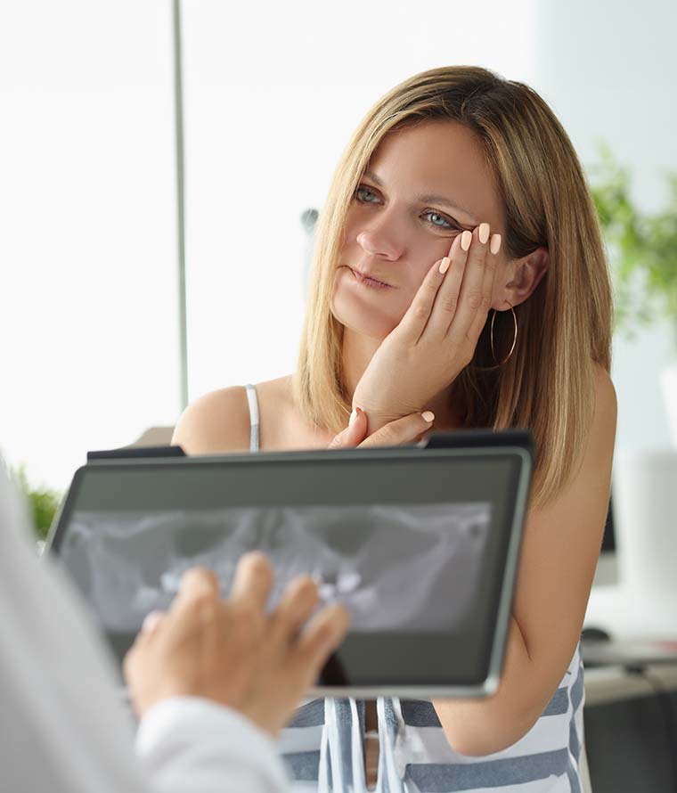 Dentist explaining a tooth extraction to a patient in Temecula